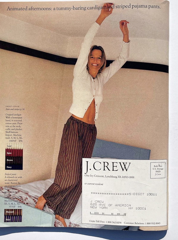 lady jumping on bed with white cardigan and brown stripe trousers