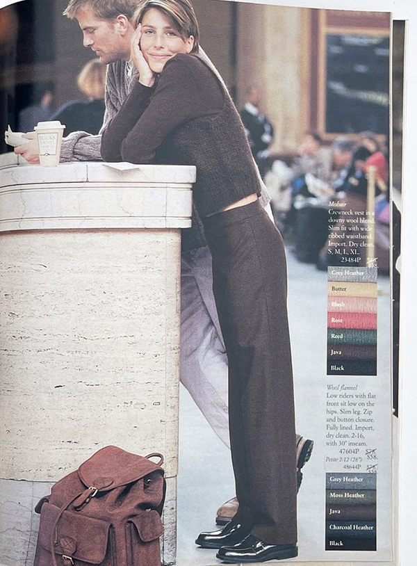 woman in brown monochrome cradigan and trousers, leaning against a pillar